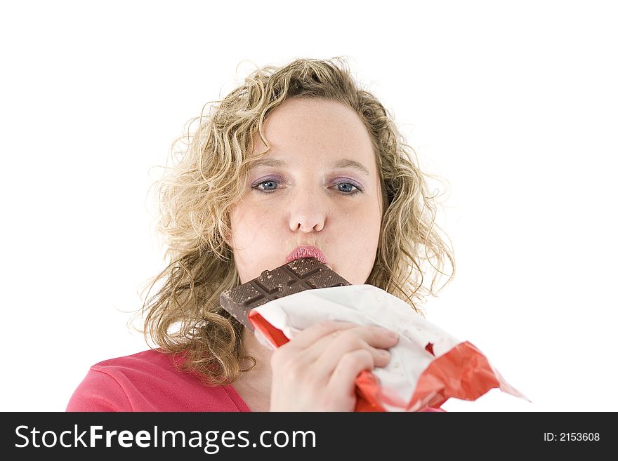 Young blond woman eats chocolate in front of the white background. Young blond woman eats chocolate in front of the white background