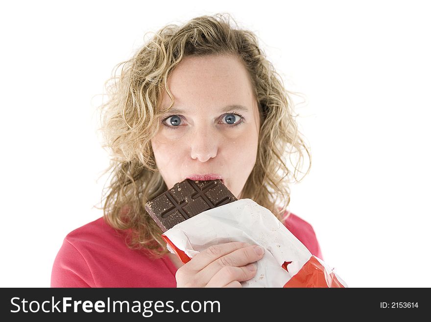 Young blond woman eats chocolate in front of the white background. Young blond woman eats chocolate in front of the white background