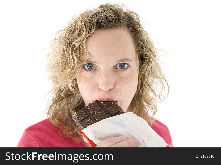 Young blond woman eats chocolate in front of the white background. Young blond woman eats chocolate in front of the white background