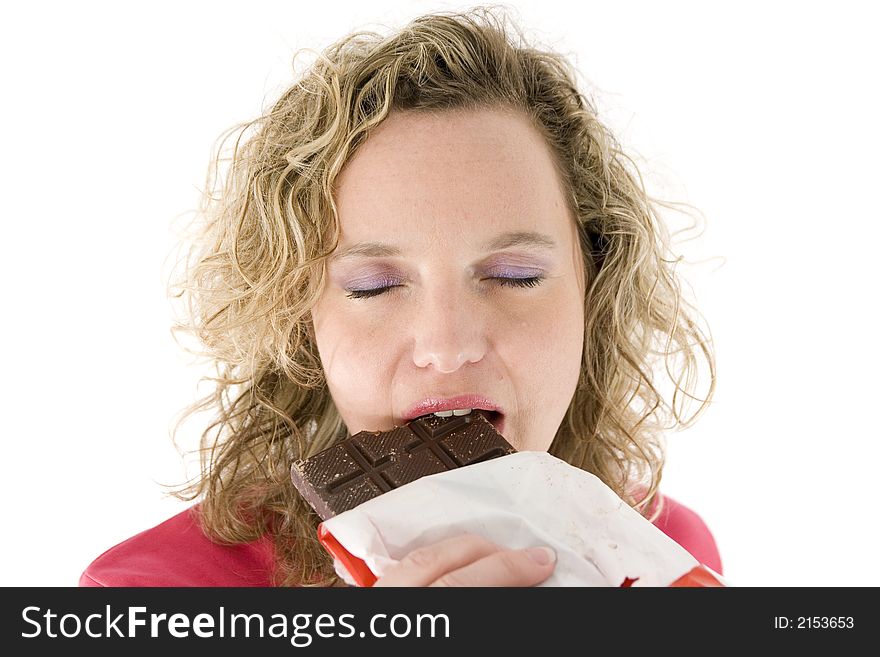 Young blond woman eats chocolate in front of the white background. Young blond woman eats chocolate in front of the white background