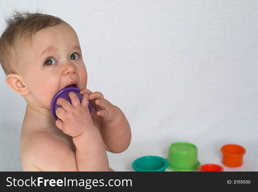 Image of adorable baby playing with colorful stacking cups. Image of adorable baby playing with colorful stacking cups