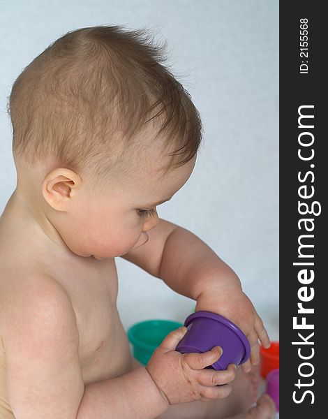 Image of adorable baby playing with colorful stacking cups. Image of adorable baby playing with colorful stacking cups