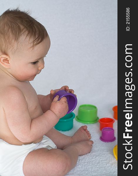 Image of adorable baby playing with colorful stacking cups. Image of adorable baby playing with colorful stacking cups