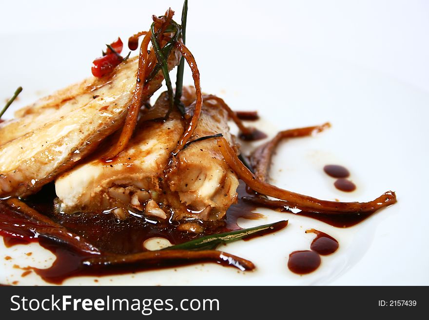 Close up of steamed red snapper with ginger, herbs and spicy sauce