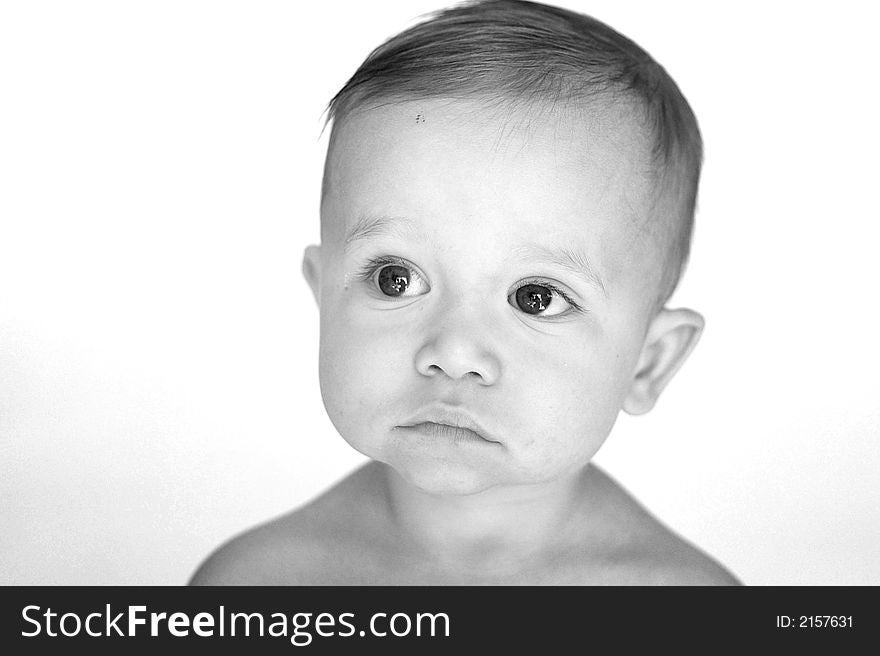 Black and white image of a beautiful 11 month old baby boy sitting in front of a white background. Black and white image of a beautiful 11 month old baby boy sitting in front of a white background