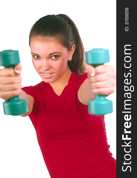 Girl in  red vest does exercises by dumbbells and aggressively looks on  white background