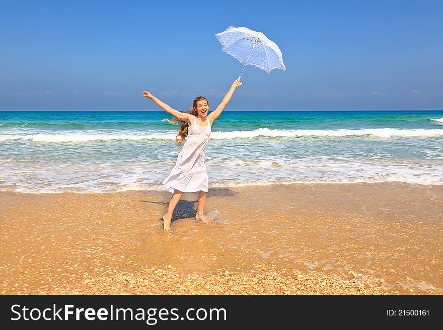 Beautiful girl in white on the beach with umbrella. Beautiful girl in white on the beach with umbrella