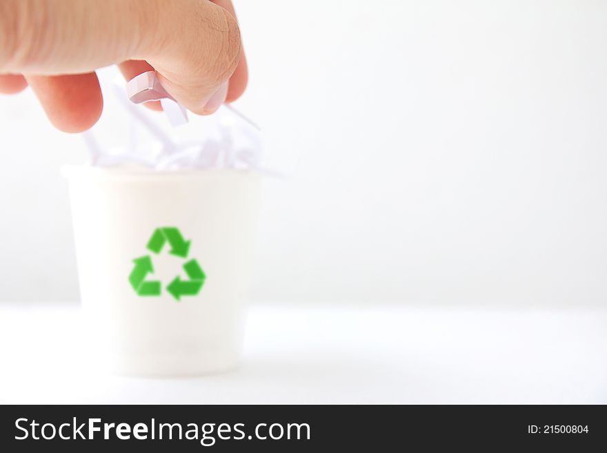 Hand drop shredded paper into the recycle bin