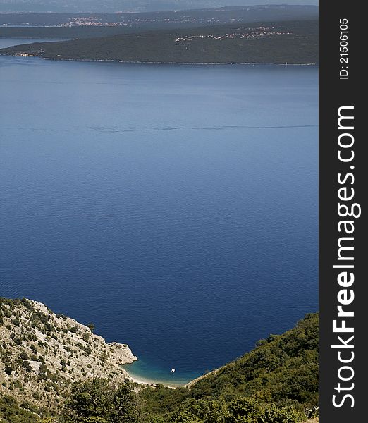 Beach on island coast with anchored boat