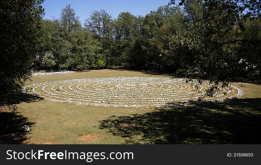 Stone labyrinth on meadow in the wood