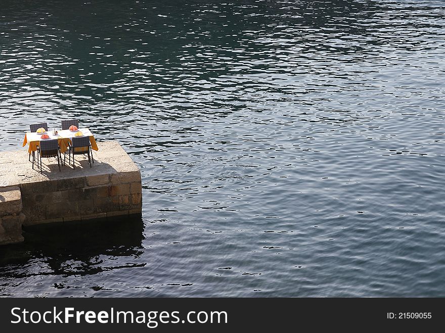 Romantic restaurant table on pier near the sea