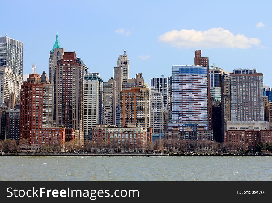 Manhattan skyscrapers, colourful New York City offices and apartments gleaming in the afternoon sun from the Hudson river. Red brick buildings, historic and modern. Manhattan skyscrapers, colourful New York City offices and apartments gleaming in the afternoon sun from the Hudson river. Red brick buildings, historic and modern