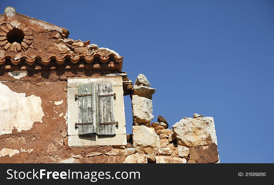 Detail of house ruin with old window and blue clear sky. Detail of house ruin with old window and blue clear sky