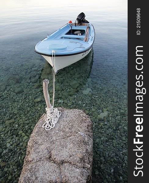 Small boat tied on small old pier