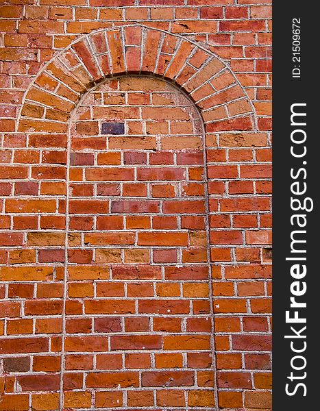 Arch with rounded top mured up with red brick. Architectural wall solutions.