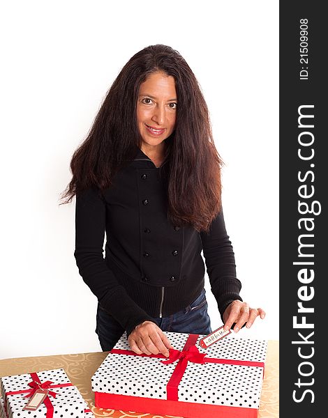 Pretty Brunette woman holding gift tag after wrapping Christmas presents. Pretty Brunette woman holding gift tag after wrapping Christmas presents