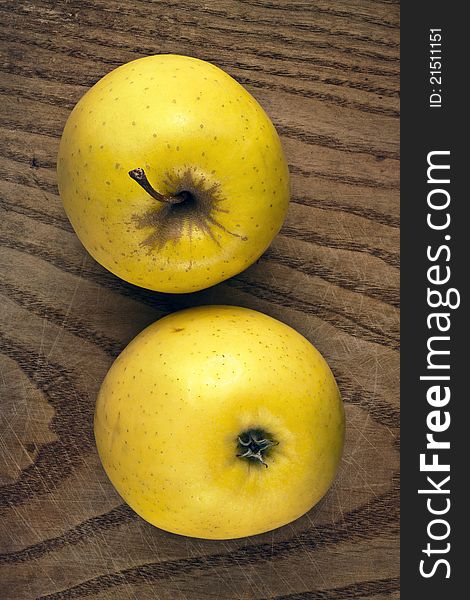Two yellow apples on a wooden plank. Clipping path is included.