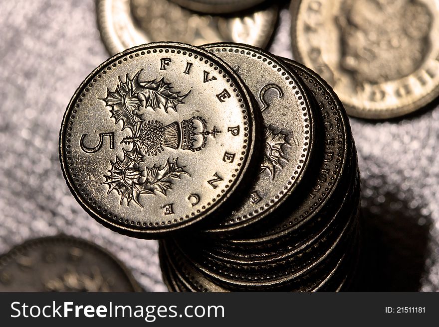 A Pile of Five Pence Coins. Shiny silver background