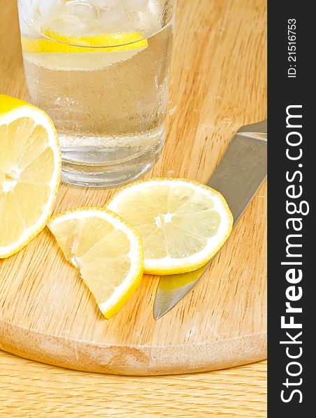 Iced water with lemon slices on chopping board. Iced water with lemon slices on chopping board