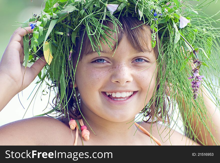 The portrate of lovely smiling girl with a wreath on a head. The portrate of lovely smiling girl with a wreath on a head