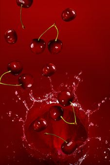 Cherry Falling Into The Lot Of Juice Stock Image