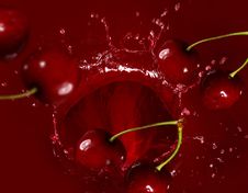 Cherry Falling Into The Lot Of Juice Royalty Free Stock Photos