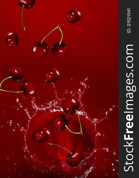 Cherry falling into the juice with huge splashes. Cherry falling into the juice with huge splashes