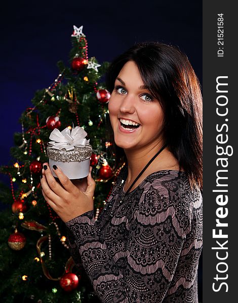 Happy and smiling woman with Christmas gift in hands. Happy and smiling woman with Christmas gift in hands