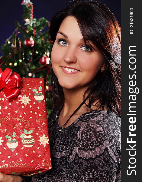 Happy and smiling woman with Christmas gift in hands. Happy and smiling woman with Christmas gift in hands