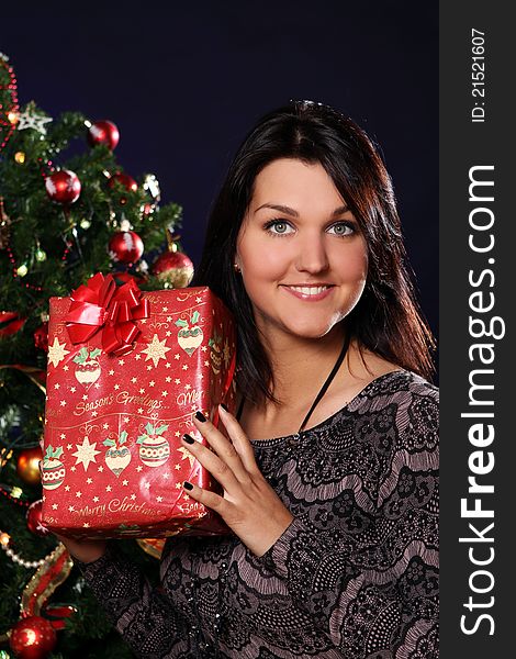 Happy and smiling woman with Christmas gift in hands. Happy and smiling woman with Christmas gift in hands