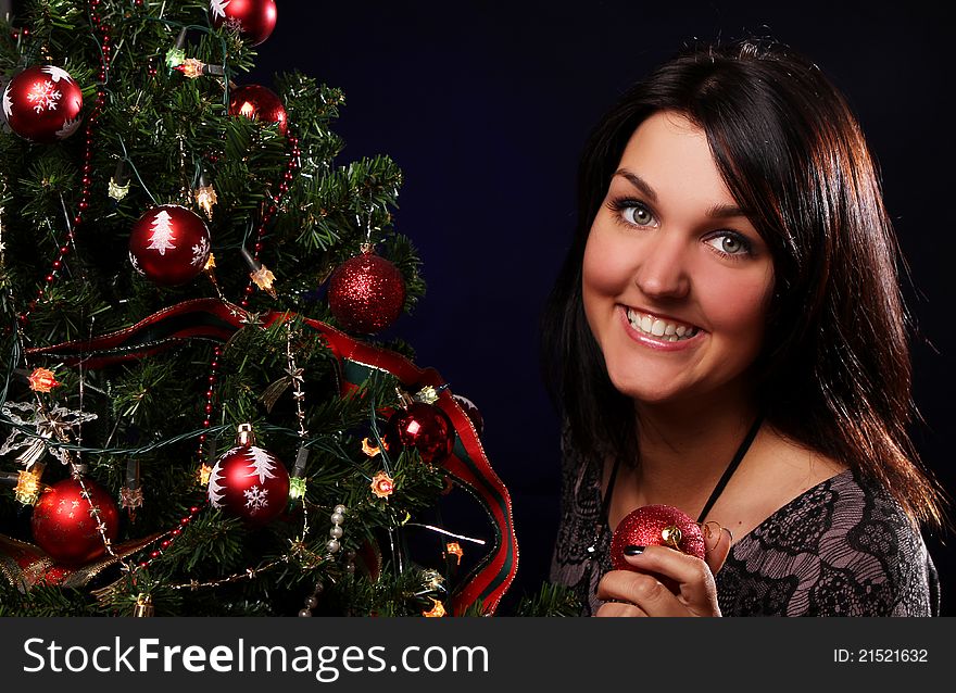 Happy woman are decorating the Christmas tree with different balls
