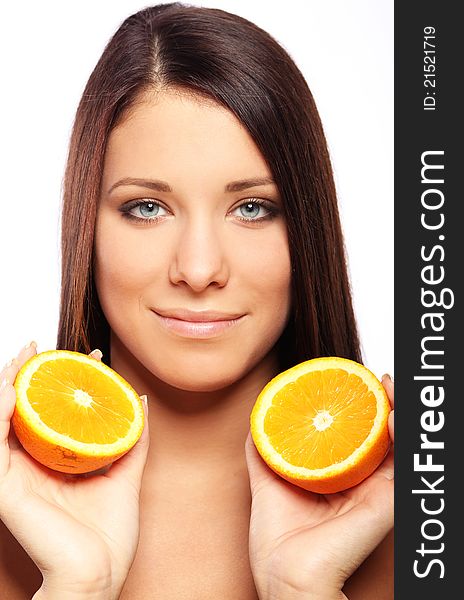 Beautiful woman with orange in hands against white background