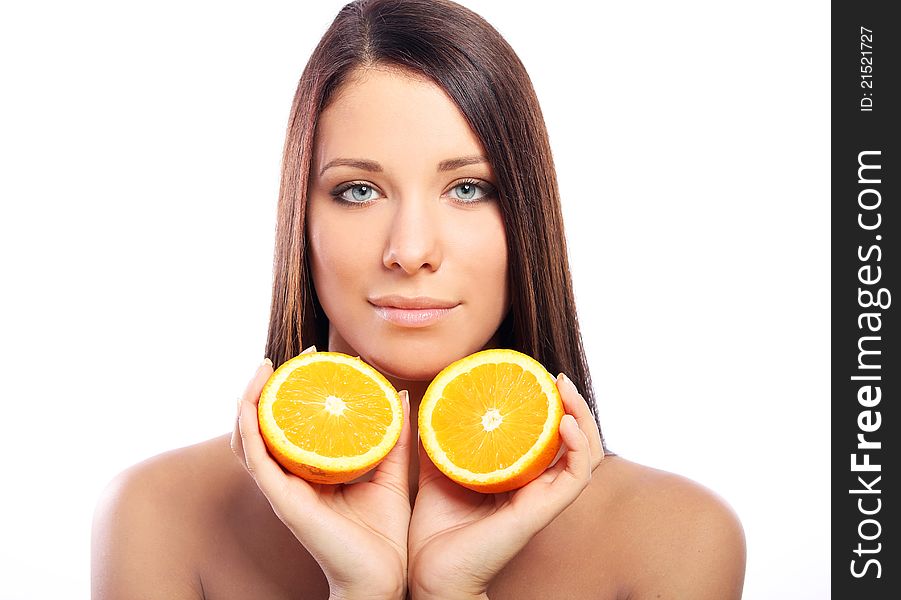 Beautiful woman with orange in hands against white background