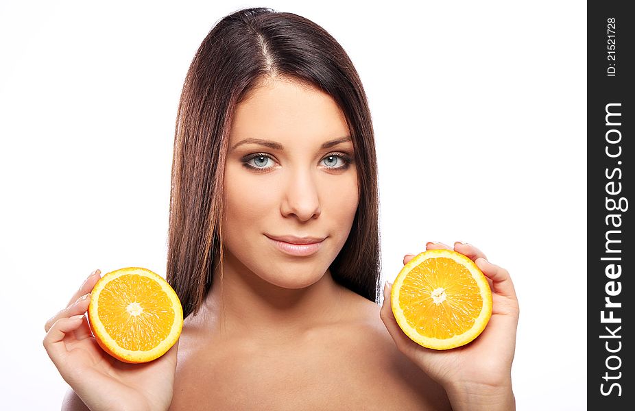 Beautiful woman with orange in hands against white background