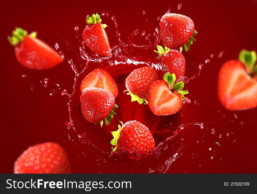 Strawberry falling into the juice with huge splashes. Strawberry falling into the juice with huge splashes