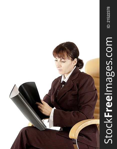 The business lady in a brown jacket sits in an armchair and a folder for papers. The business lady in a brown jacket sits in an armchair and a folder for papers