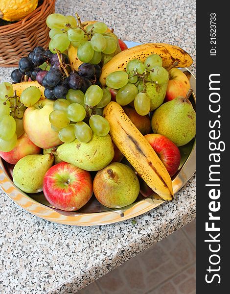 Assorted fruit plateau on grey outdoor table.