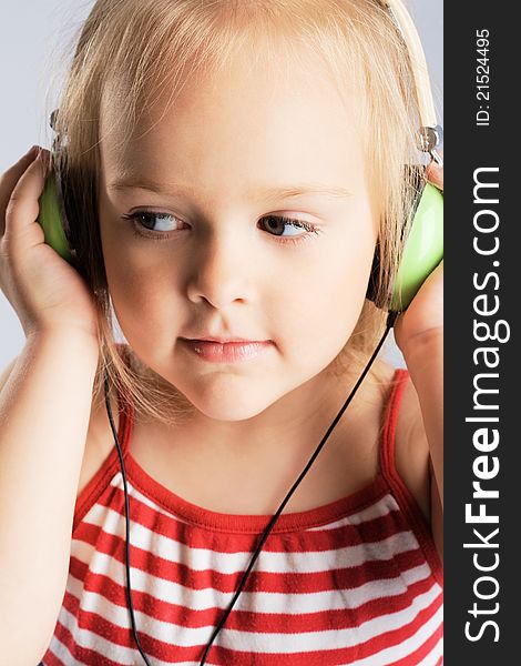 Little girl listening a music in earphones