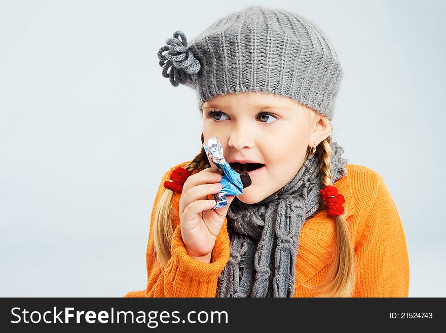 Lovely little girl eating a candy