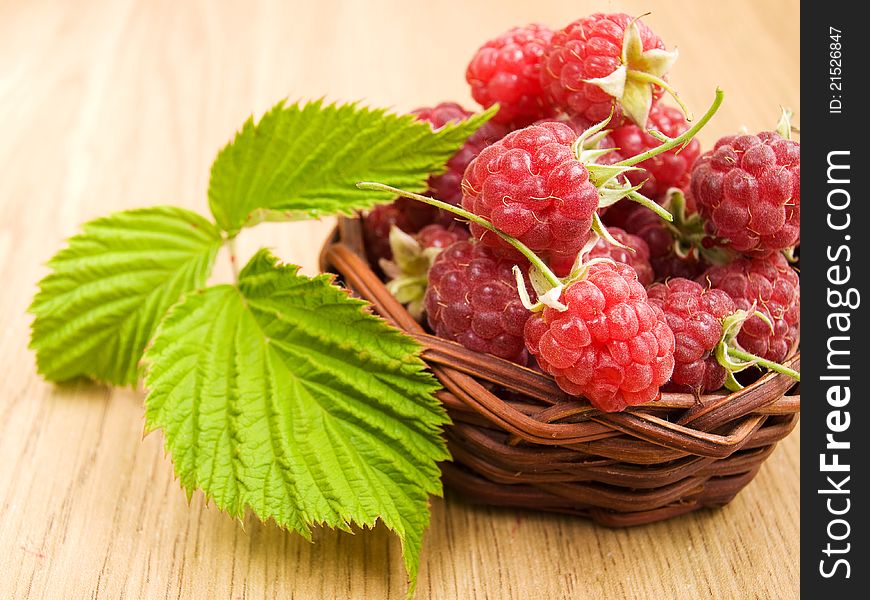 Raspberries in the basket on the table