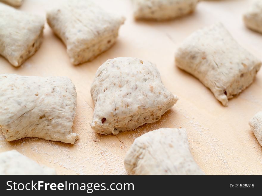 Pieces of fresh dough for buns waiting to be baked in the oven. Pieces of fresh dough for buns waiting to be baked in the oven.