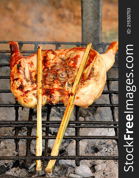 Grilled chicken over gridiron and low heat from natural charcoal