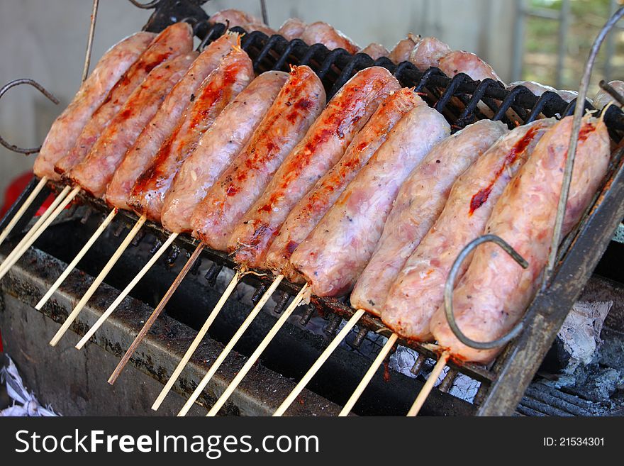 Grilled sausages over gridiron and low heat from natural charcoal