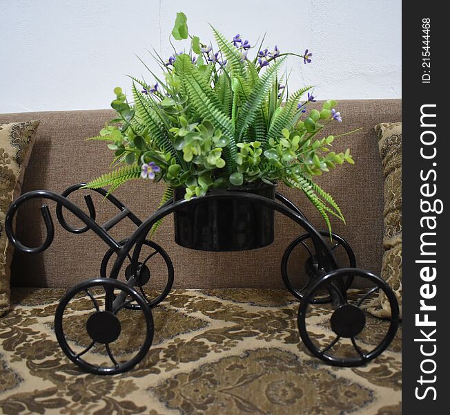 This is a beautiful cart with a vase having amazing green plant with purple flowers. This is a beautiful cart with a vase having amazing green plant with purple flowers.