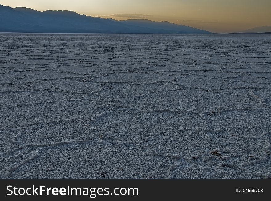 The prismatic sodium borite flats of Death Valley National Park, California (The lowest point in North America) stretch off into the distance under a sunset. The prismatic sodium borite flats of Death Valley National Park, California (The lowest point in North America) stretch off into the distance under a sunset.