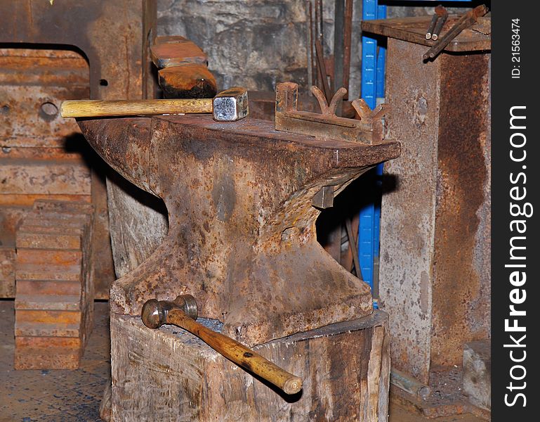 Rusty Iron Anvil in a Machine Shop with Hammer and Mallet. Rusty Iron Anvil in a Machine Shop with Hammer and Mallet