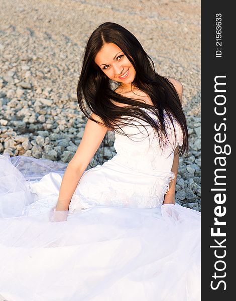 Portrait of a beautiful bride on pebbles outdoor