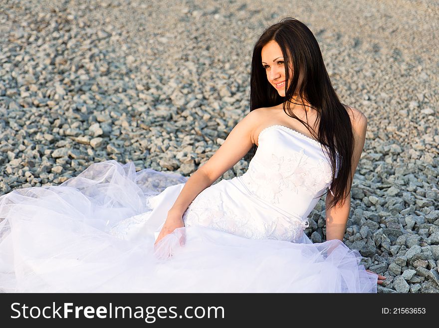 Portrait of a beautiful bride on pebbles