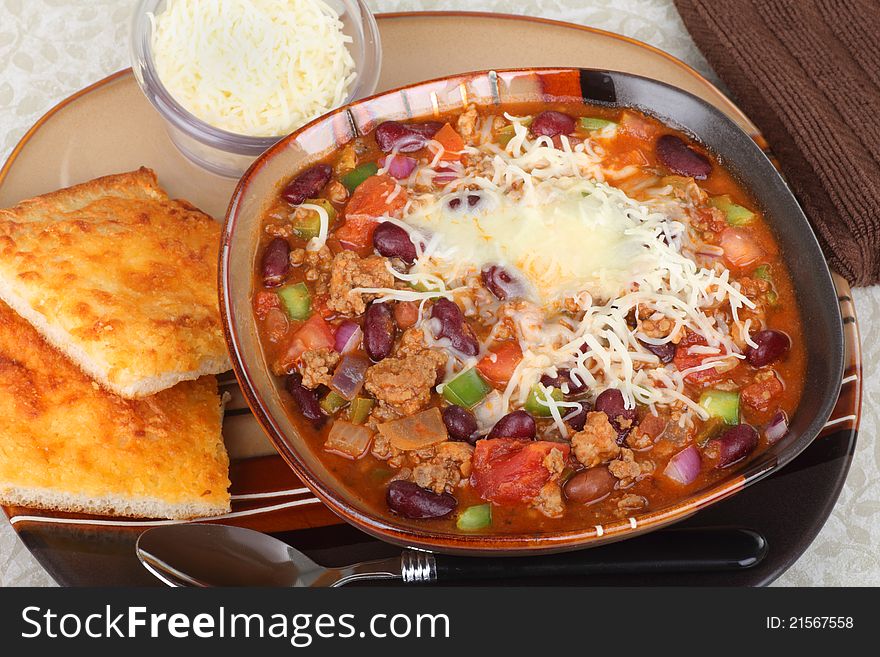 Bowl of chili with melted cheese and cheese bread. Bowl of chili with melted cheese and cheese bread