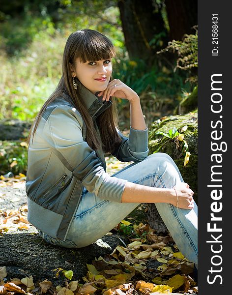 Pretty young woman sitting in park. Pretty young woman sitting in park